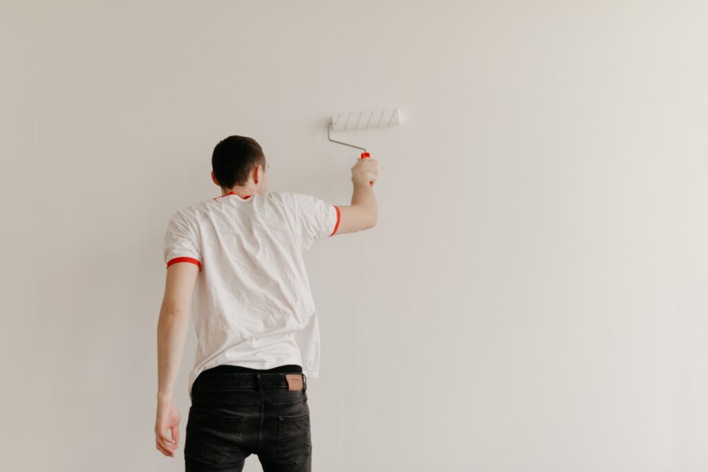 Кадр 2 человек в белом красит стену