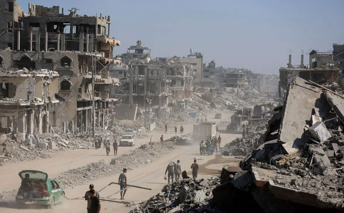 Палестинцы проходят мимо обломков разрушенных зданий в Газе, 16 октября 2025 года (Dawoud Abu Alkas / Reuters)