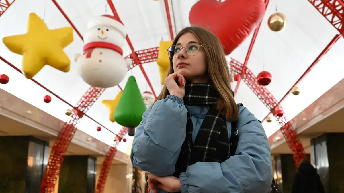 Студентка Алина Минакова рассматривает новое украшение станции метро «Трубная»