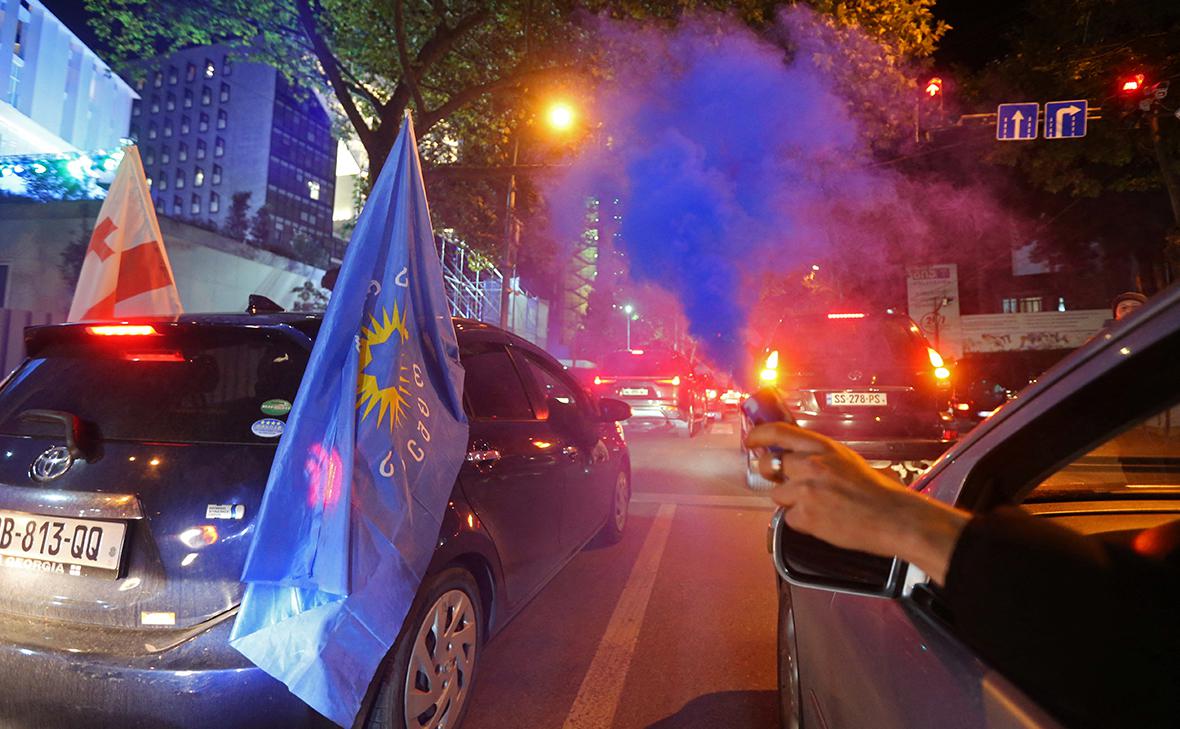 <p>Сторонники партии Грузинская мечта празднуют после объявления результатов на парламентских выборах</p> (Irakli Gedenidze / Reuters)