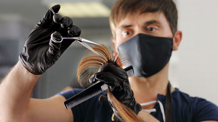 AHairdresserCutsTheLongHairOfAYoungGirl