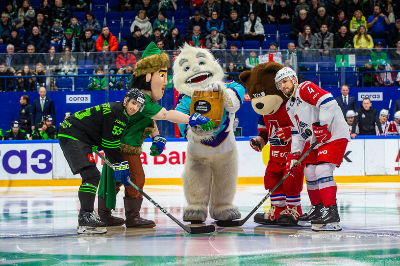 Хоккеисты ХК «Салават Юлаев» Саша Хмелевски (слева) и ХК «Локомотив» Александр Елесин вместе с талисманами команд и талисманом Фонбет КХЛ Крутом