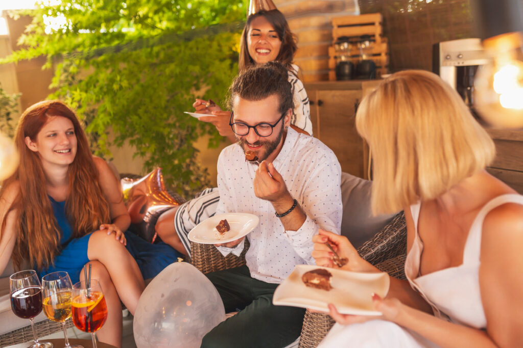 друзья наслаждаются тортом на празднике