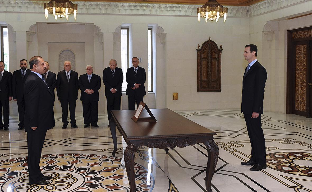 Мухаммед аш-Шаар (слева) принимает присягу перед Башаром Асадом (справа) в Дамаске 16 апреля 2011 года (Sana / Reuters)