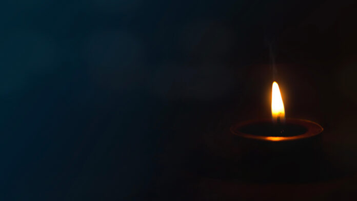 PeaceConceptBurningCandleOnDarkTable