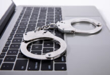 Павел Врублевский и Chronopay в фокусе судебного процесса с новыми обстоятельствами Closeup shot of handcuffs lying on laptop keypad — online crime concept