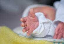 TheNewbornBabysHandReachesOutAsIfTryingTo