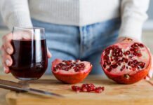 Гранат — природный источник молодости и здоровья YoungWomanPeelingAPomegranateAndHoldingAGlassOf