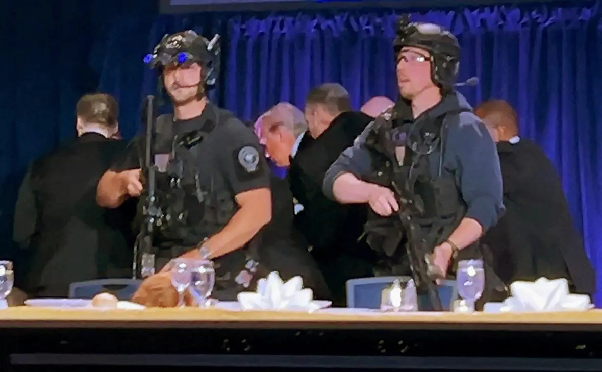 Дональда Трампа выводят из зала после того, как мужчина открыл огонь из дробовика по сотрудникам службы безопасности за пределами помещения (Bo Erickson / Reuters)