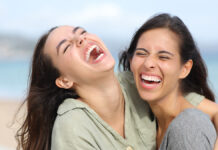 Замечательные праздники 24 января радуют душу и дарят улыбки TwoJoyfulFriendsLaughingHilariouslyOnTheBeachaAndHugging