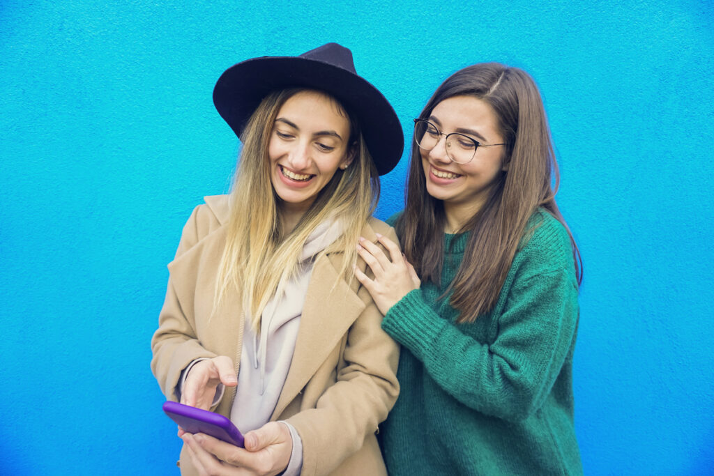 две подруги смотрят видео в телефоне