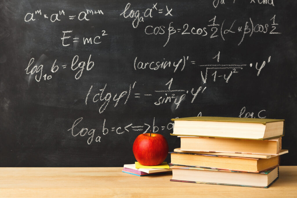 Формулы на доске, яблоко и книги