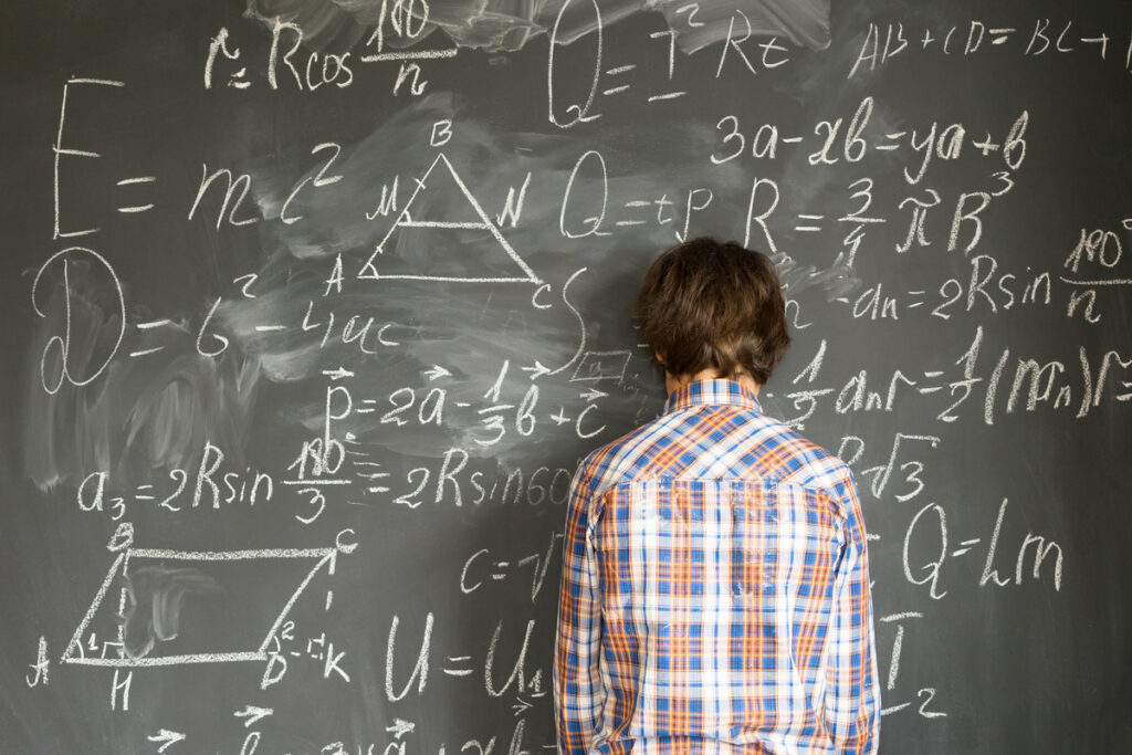 Ученик решает примеры на умножение на доске