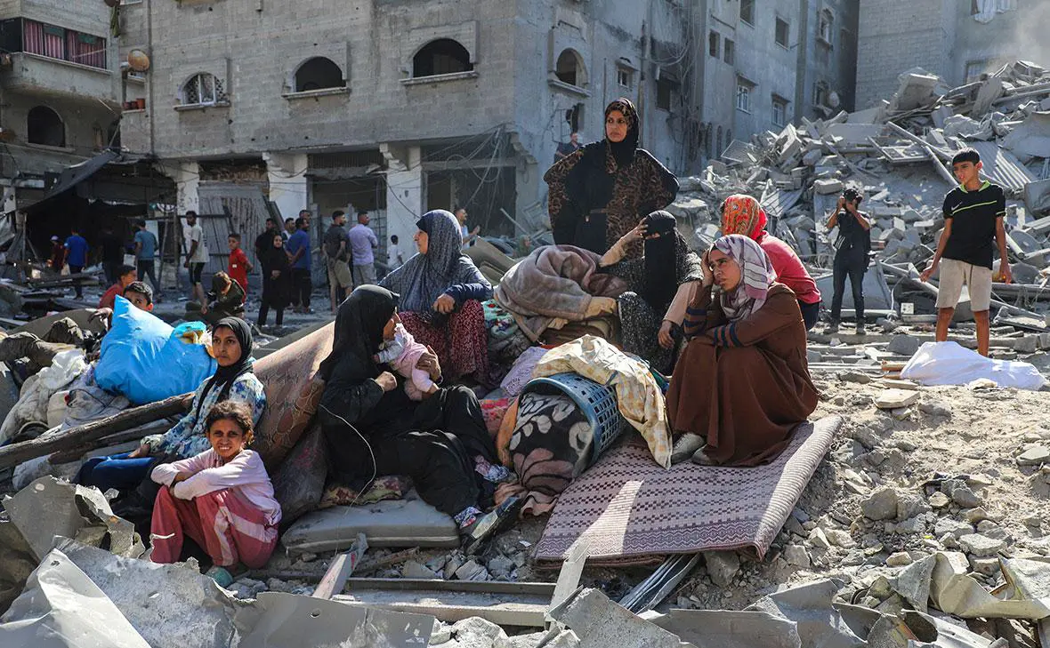 Палестинцы рядом с местом израильских авиаударов в Газе, 12 сентября 2025 года (Ebrahim Hajjaj / Reuters)