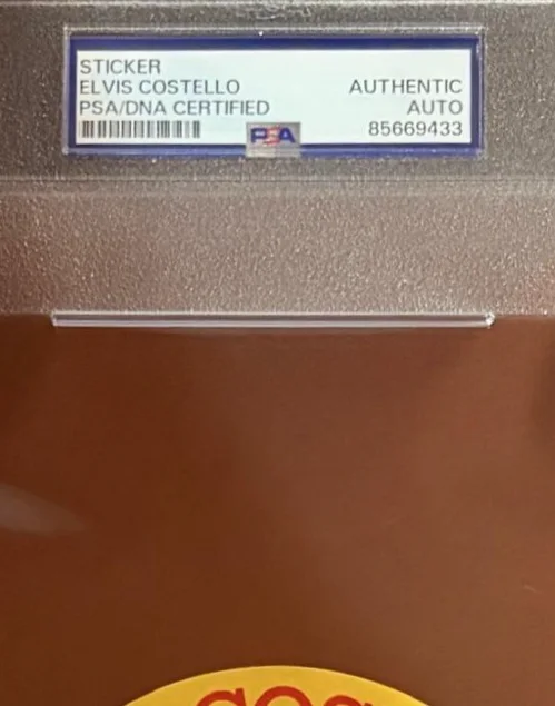 Elvis Costello — ELVIS COSTELLO SIGNED AUTOGRAPH STICKER ENCAPSULATED PSA RARE MY AIM IS TRUE, image 3