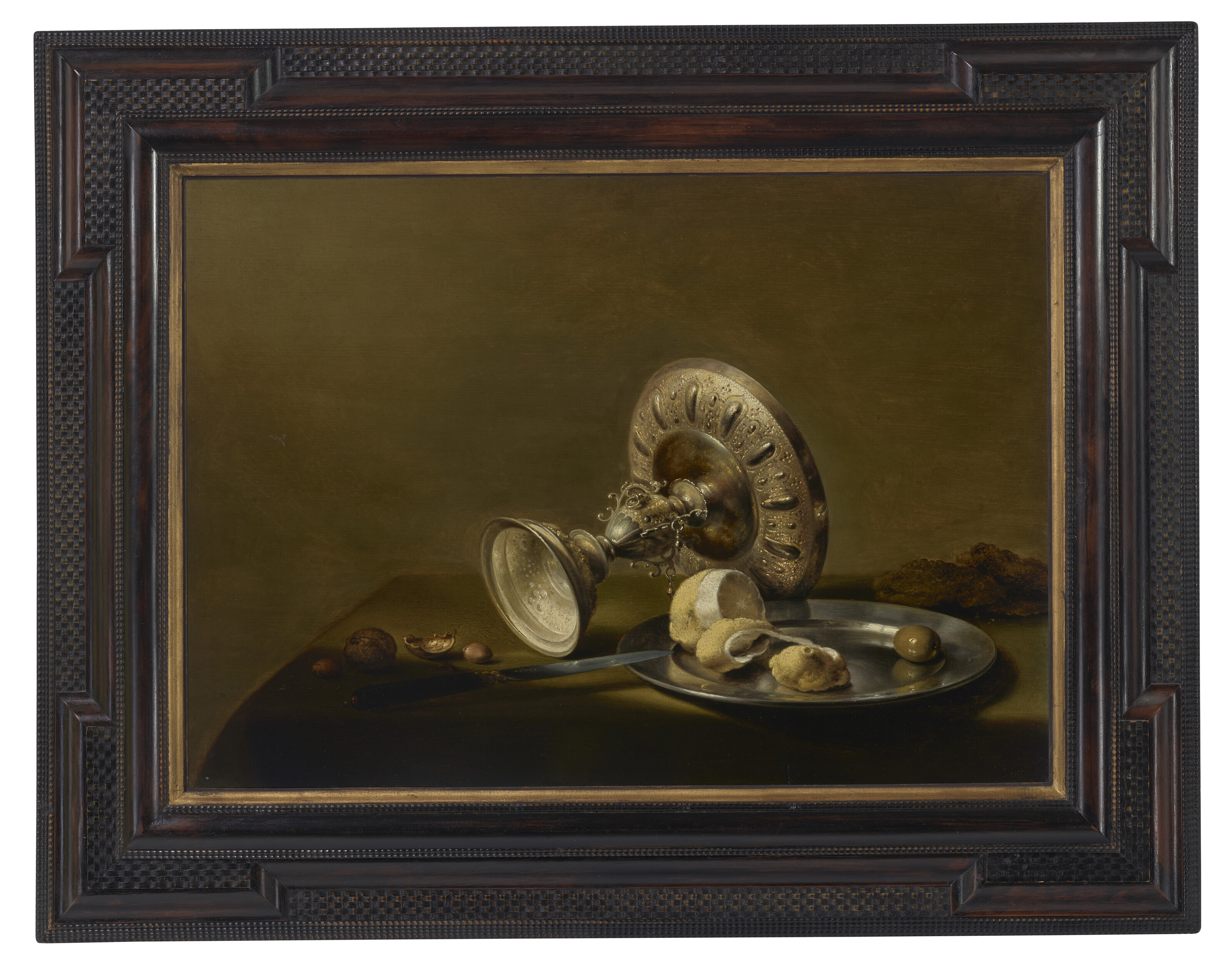 Pieter Claesz — Перевернутая серебряная тазца, частично очищенный лимон и оливка на серебряной тарелке, грецкие орехи, фундук и нож на задрапированном столе, изображение 2