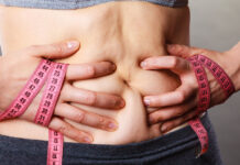 Прорыв в лечении диабета и ожирения с помощью кишечных бактерий Woman touching stomach holding measuring tape