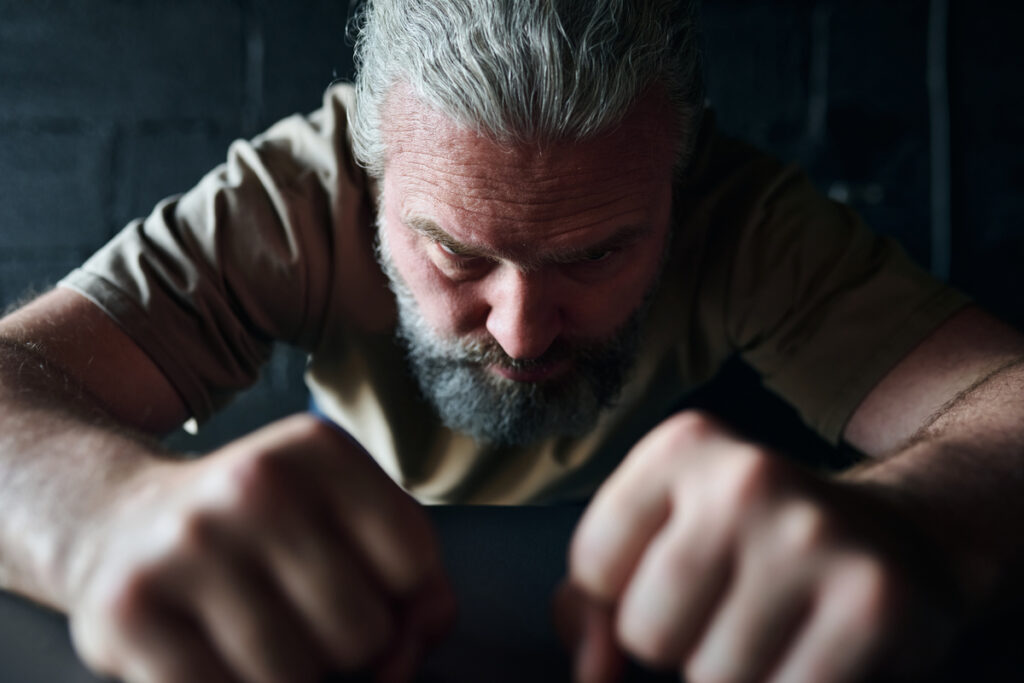 мужчина сжимает кулаки от ярости