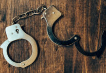 Uncuffed open hand cuffs on wooden desk top view