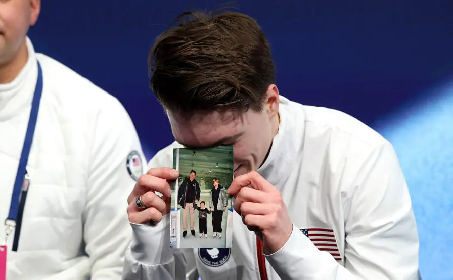 Фигурист Максим Наумов держит фотографию погибших родителей в авиакатастрофе (Matthew Stockman / Getty Images)