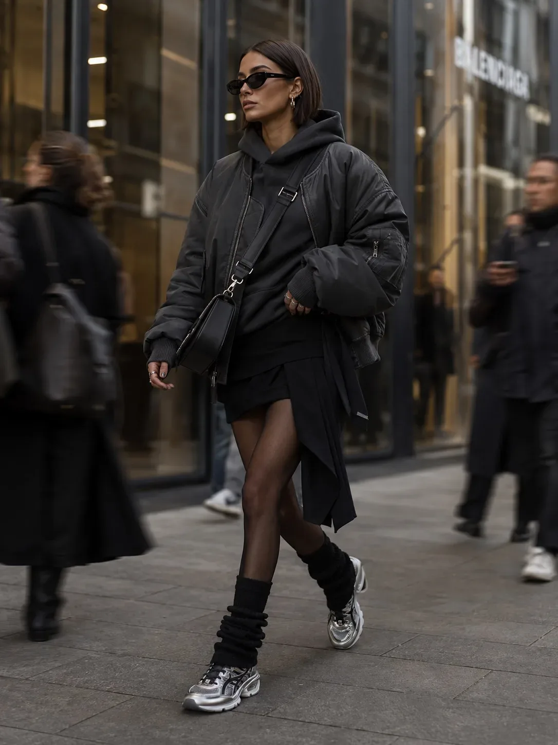 high-fashion editorial street style scene in a modern luxury shopping district, oversized charcoal b